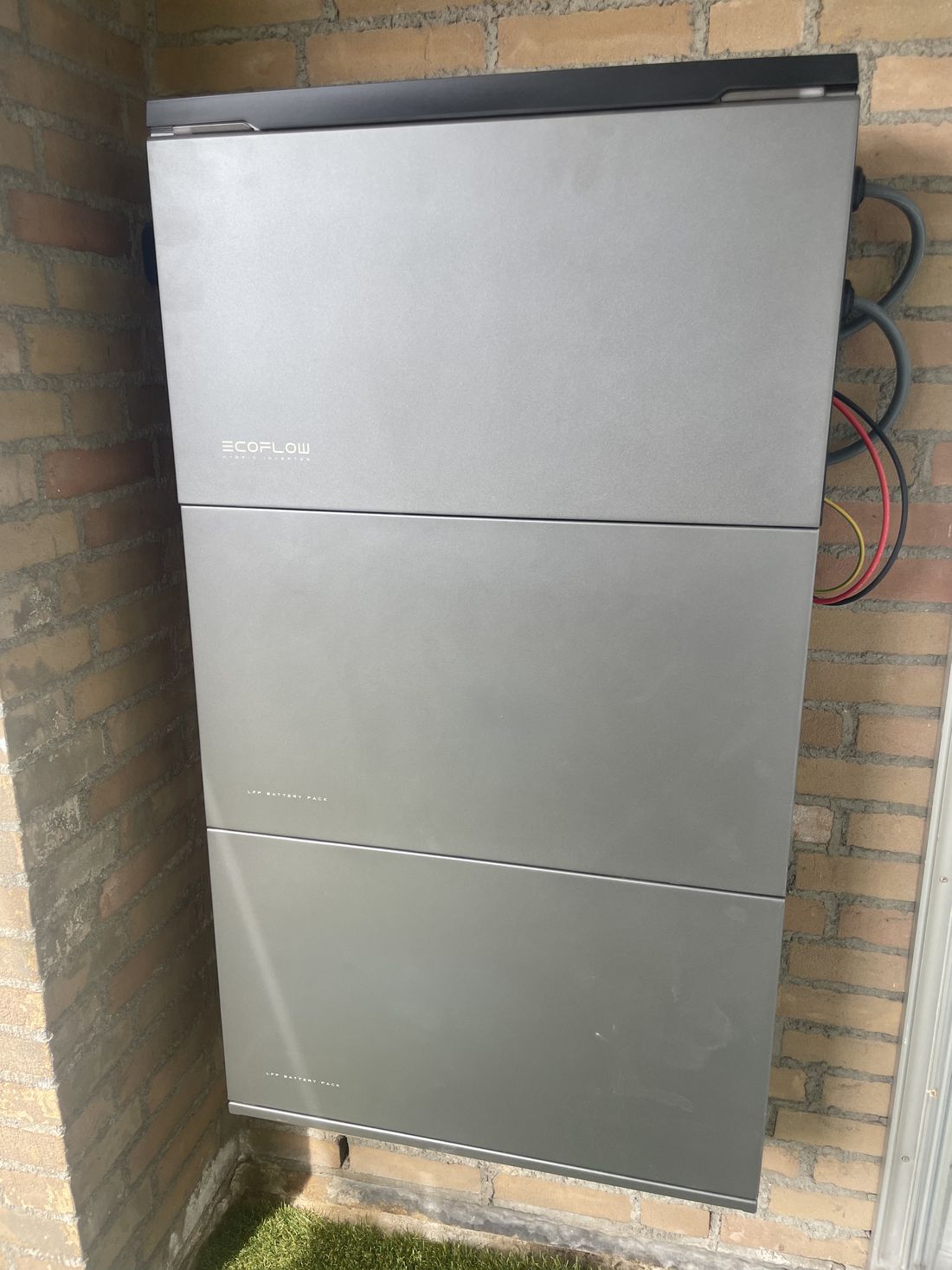 Thuisbatterij gemonteerd tegen een buitenmuur